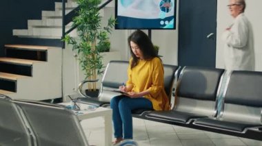 Hemşire ve Asyalı hasta sağlık muayenesi yapıyor, check-up raporlarını inceliyor. Bekleme odasındaki randevuda dijital tablet kullanmak, sağlık desteğinden bahsetmek....