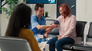 Hipertansiyon ve nabız basıncını ölçmek için tonometreyle kalp muayenesi yapan bir tıp asistanı. Sağlık kliniğindeki kan basıncını ölçmek için tıbbi alet kullanan hemşire..