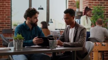 Business men analyzing charts data on digital tablet, doign teamwork collaboration to plan research presentation with graphs on paperwork. Analyzing report information on documents. Tripod shot.
