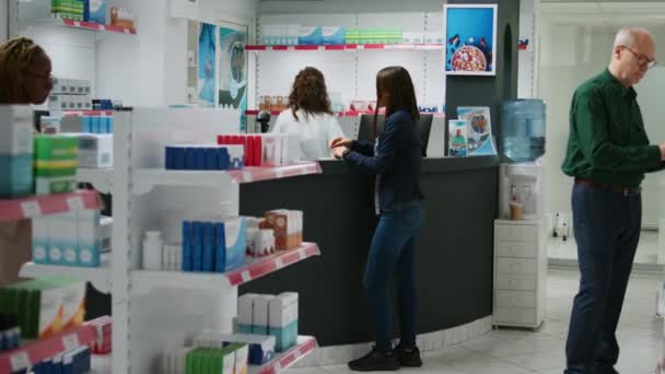 전문가들은 카운터에 고객에게 전단지를 설명하며 보조제에 이야기하고 약국에서 의약품을 취급하는 — 비디오