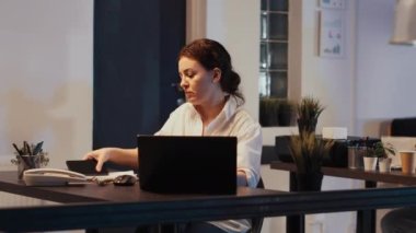Bayan yönetici gece geç saatlerde akıllı telefonla konuşuyor, cep telefonu hattını kullanarak çalışanlarla sohbet ediyor ve iş planlama toplantısını planlıyor. Sunum yapmak için uzaktan konuşma yapmak.