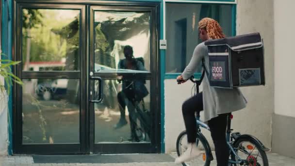 送货员携带背包运送速递食品订单 并向顾客提供装有午餐的纸袋 随行骑自行车 并在办公室前门送上餐厅食品包 — 图库视频影像
