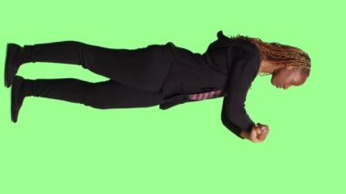 Dikey video: Genç yetişkin dur işareti gösteriyor ve x şeklinde kolları var, tüm vücudu yeşil ekran arkaplanının üzerinde duruyor. Reddetme jesti yapan, onaylamayan ve reddeden veya inkar eden kişi.