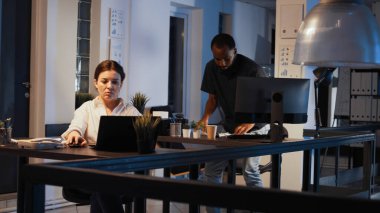 Meslektaşları ayrıldıktan sonra geceleri çalışan kendine güvenen bir kadın, rapor hazırlamak ve veri araştırmalarıyla sunum yapmak için dizüstü bilgisayar kullanıyor. Yazılım ağı planlanıyor ve e- posta gönderiliyor.