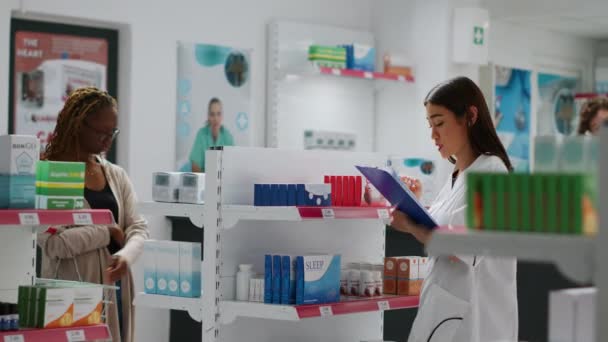 薬局の棚で医薬品やサプリメントをチェックしている医療従事者 薬や薬を扱う薬剤師は 顧客を助けるために パッケージやボックスを見て — ストック動画