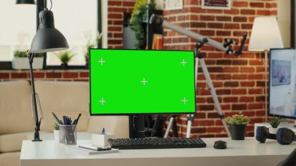 モニター上の緑の画面テンプレートと空の作業テーブル コンピュータ上で実行されている隔離されたモックアップの背景 クロマキーディスプレイ上の空白のコピースペースを持つデスクトップPc 緑の画面をモック — ストック動画