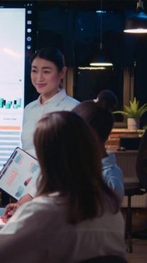 Dikey video: Şirketin yıllık yatırım kâr raporunu sunan çeşitli iş arkadaşları, birlikte çalışma alanında çalışan planlaması satış stratejisi. Ofis çalışanları iş toplantısında, veri grafikleri dijital