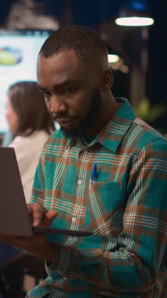 Vertikal Video Afrikansk Amerikansk Anställd Arbetar Laptop Tittar Kameran Ler — Stockvideo