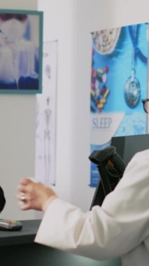 Dikey video: Yaşlı müşteri eczane tezgahına ilaç kutuları koyuyor, reçete tedavisi için ilaç ve takviye malzemeleri alıyor. Eczacılık ürünlerini alışveriş poşetinde nakit olarak alan bir adam.
