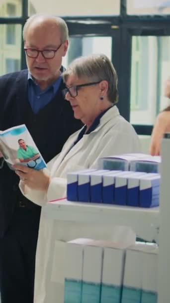 Вертикальне Відео Фахівець Охорони Здоров Читає Аптечні Листівки Літнім Клієнтам — стокове відео