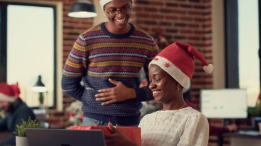 Afrika kökenli Amerikalılar Noel ağacı ya da süs eşyasıyla süslenmiş Noel hediyelerini takas ediyorlar. Erkek kadına hediye veriyor, kış tatilini şenlikli süslemelerle kutluyor..