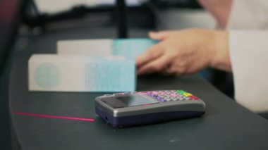 Müşteri eczane ürünlerini akıllı sehpayla alıyor, tersanede NFC ödemesi yapıyor. Eczanede ilaçlara hiç para ödemeyen bir kadın. Kapatın. El kamerasıyla..