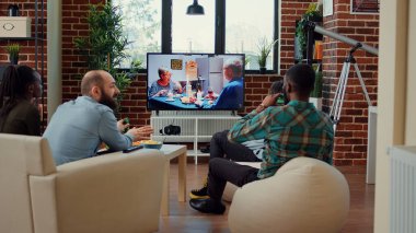 TV kanalında film izleyen, bira içen ve eğlence toplantısında abur cubur yiyen çok ırklı bir arkadaş grubu. Mutlu insanlar televizyon programında ya da sinema filminde eğleniyor..