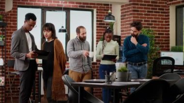 Portrait of multiethnic group doing teamwork on presentation, planning research project to create business partnership. People working on professional report with data. Tripod shot.