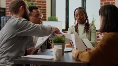 Çevrimiçi istatistik ve veri raporuyla başarılı bir sunum yaratmak için ekip çalışması yapan iş adamları. Tabletteki bilgi araştırmaları ve çizelgeler ile proje analizi planlanıyor. Üçayak atışı.