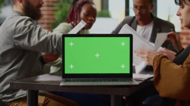 Evrak işleriyle uğraşan iş adamları, laptopta yeşil ekran, işbirliğini planlıyorlar. Renkli anahtar görüntüsü ve telif alanı arkaplanı olan boş model şablonu kullanılıyor. Kapat..