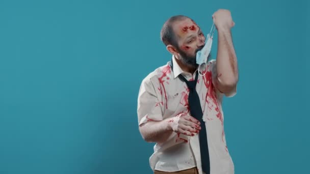 Scary Zombie Trying Put Covid Protection Mask While Standing Blue — Stock Video