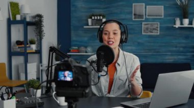 Cheerful popular internet podcast show host ending live stream while sending air kisses to public. Social media popular infulencer saying goodbye to audience while sitting at home studio desk.