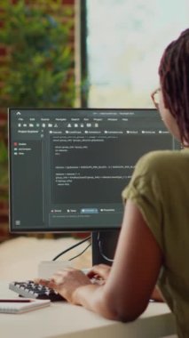 Dikey video: Genç bir kadın yeni çevrimiçi uygulama geliştirmek için kaynak kod kullanıyor, terminal penceresindeki html betikle veritabanı yazılımını programlıyor. BT yöneticisi yapay zeka ağı planlıyor.