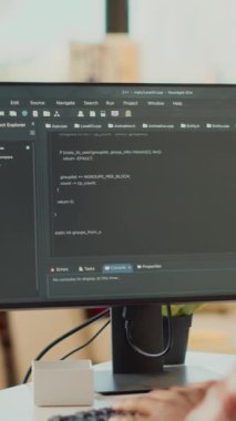 Dikey video: Freelancer yönetici html kodunu bilgisayarda programlıyor, evden uzakta çevrimiçi web betiği ve veritabanı ile çalışıyor. Uçbirim penceresi ve yapay zeka kullanılarak, uygulama geliştirici.