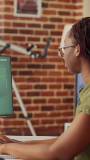 垂直录像 非洲裔美国妇女通过计算机上的财务图表远程处理数据销售报告 在公司网络上做会计工作的自由职业者 分析互联网 — 图库视频影像