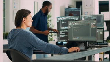Yazılım geliştiricisi bilgisayarda öğrenme uygulaması kodları yazıyor, büyük veri ofisindeki masada oturuyor. Bulut programcısı siber güvenlik ajansında Html veritabanı senaryosu üzerinde çalışıyor. El kamerasıyla..