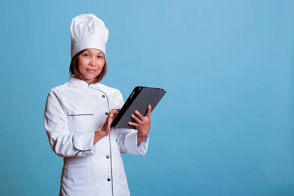 Önlüklü Beyaz Üniformalı Asyalı Aşçı Gastronomi Sitesinde Tablet Bilgisayarlı Yemek — Stok fotoğraf