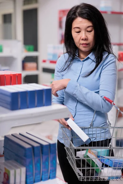 アジアの女性は 処方薬や医療製品を購入するバスケットに薬の箱を置く 病気を治すために医薬品パッケージを取るクライアント 医療用品カプセル — ストック写真