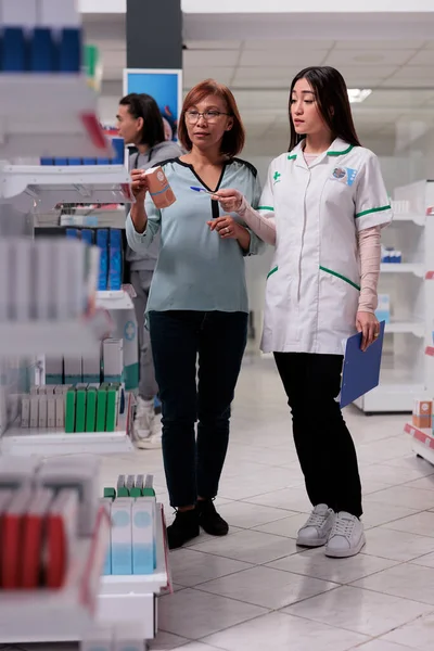 Müşteri Eczacı Raflardaki Tıbbi Ürünleri Inceliyor Bir Kutu Takviye Veya — Stok fotoğraf
