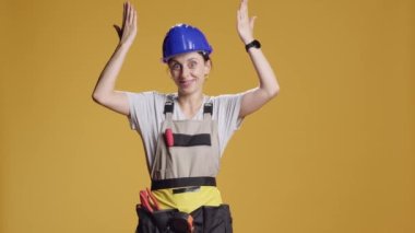 İşinin ehli kadın yukarı yönde reklam vermek ve inşaat inşaatında çalışmak için yukarı işaret ediyor. Müteahhit, yukarıdaki stüdyoda ve mühendislik üniformasında reklam olduğunu belirtiyor..