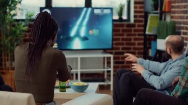 Çok ırklı bir grup insan televizyon konsolunda bilgisayar oyunlarından zevk alıyor, arkadaş toplantılarında online yarışmalar yapıyorlar. TV 'de oyun oynamak, bira içmek, eğlence aktivitesi..