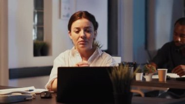 Bilgisayardaki çevrimiçi video konferansına katılan bir kadın, gece uzaktan video konferans görüşmesiyle web kamerasından insanlarla konuşuyor. Telekonferansta sohbet, internet telekomünikasyon.
