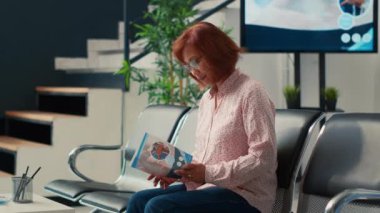 Asyalı yaşlı bir hastanın portresi hastane lobisinde hastalık tedavisi hakkında konuşmak için bekliyor. Reçeteli ilaç almak ve hastalıkları tedavi etmek için sağlık sigortasına sahip olmak. El kamerasıyla..