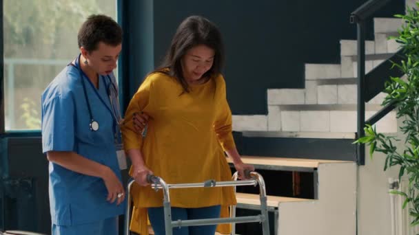 Zdravotní Specialista Podporující Asijského Pacienta Chodit Zlomeninou Nohy Pomocí Chodící — Stock video