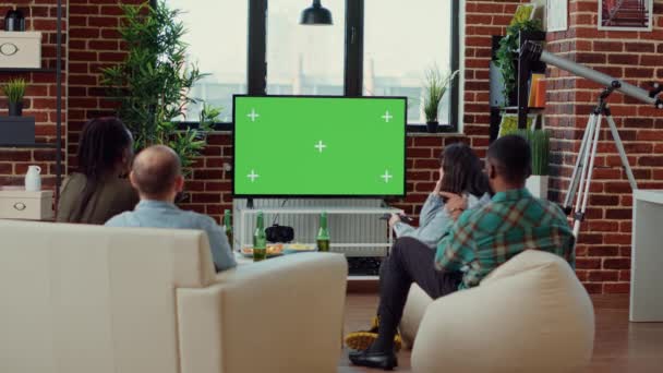 不同的人在绿屏模板上切换电视频道 观看电视节目和观看孤立的彩色关键背景 使用空白的模拟复制空间 三脚架射击 — 图库视频影像