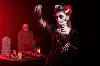 Santa Muerte vücut sanatı ve makyaj modeli kutsal Meksika geleneğini kutlamak için La Cavalera Catrina 'ya benziyor. Kafatası boyası ve çiçek takmak Dios de los Muertos ayininde taç giymek.