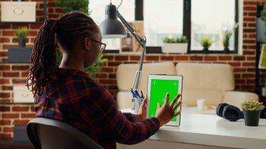 Dikey olarak, yeşil ekran şablonu olan modern cihazları tutan kadın işçiler, izole edilmiş arka plan ve maketlerle boş şablonları analiz ediyorlar. Kopyalama alanı krom anahtar ekranı kullanılıyor.