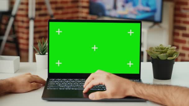 在笔记本电脑上工作的男性自由职业者在办公桌前使用绿色屏幕模板 检查空白色键 并在手提电脑上独立显示 用模拟的复制空间查看Pc 三脚架射击 靠近点 — 图库视频影像