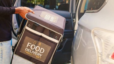 Afro-Amerikan uçak gemisi arabadan yemek teslimatı için çıkıyor, araçtan ayrılıyor ve müşteriye fast food siparişi veriyor. Teslimat servisi çalışanı öğle yemeği için zili çalıyor..