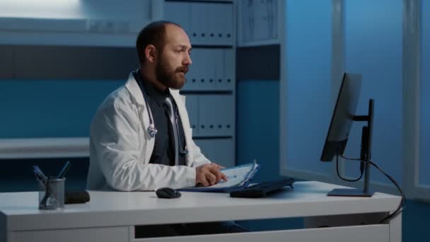 Pratisyen Doktor Bilgisayardaki Tıbbi Verileri Kağıt Üzerinde Yazılmış Uzmanlıkla Karşılaştırıyor — Stok video