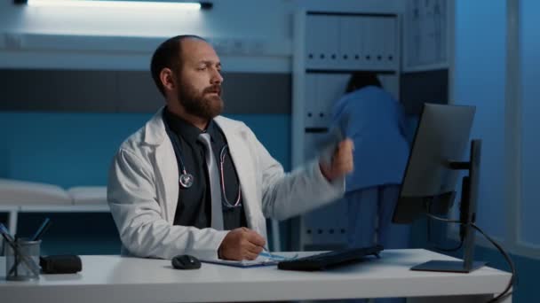 의사는 병원에서 일하면서 컴퓨터로 기술을 입력하는 방사선 검사를 환자의 치료에 — 비디오