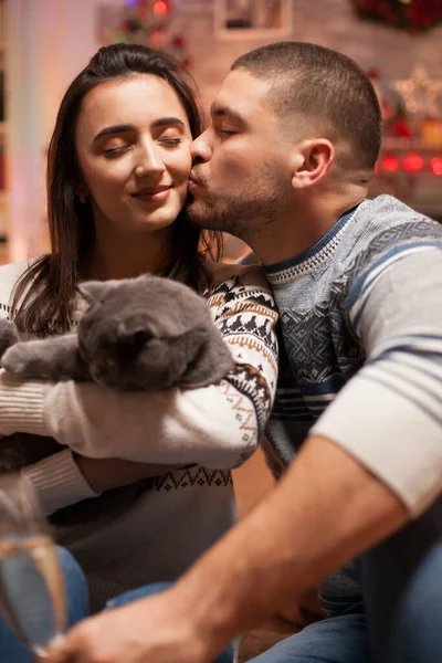 Fidanzato Baciare Sua Ragazza Guancia Mentre Tiene Gatto Natale — Foto Stock