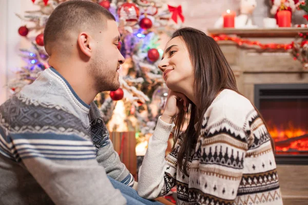 一对快乐的年轻夫妇在圣诞节互相望着对方的画像 — 图库照片