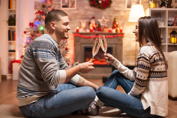 在庆祝圣诞节的时候 这对欢欢喜喜的夫妇一边喝着一杯香槟 一边笑着 — 图库照片