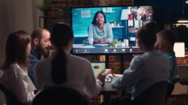 Video konferansında uzaktan kumandalı iş arkadaşlarını dinleyen çalışanlar, gece saatlerinde video konferansında konuşan meslektaşlar. Ofis çalışanları toplantı odasında telekonferansta sohbet ediyorlar.