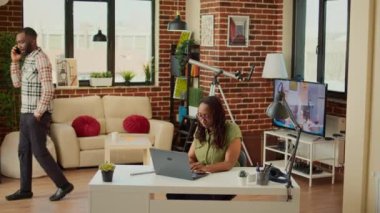 Evde dizüstü bilgisayarla çalışan serbest çalışan bir kadın erkek arkadaşıyla oturma odasında şirket veri raporu hazırlıyor. Ofis çalışanı masada oturuyor ve muhasebe işlerini yapıyor, profesyonel e-posta gönderiyor..