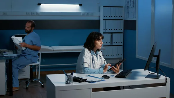 タブレットを持っている専門家の女性は 病院のオフィスでほぼシフトを作業しながら コンピュータ上の医療専門知識を入力体の放射線分析 ヘルスケアサービスとコンセプト — ストック写真
