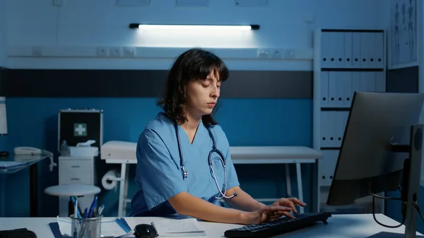 Doctor Assistant Standing Desk Late Night Hospital Office Typing Medical — Stock Photo, Image