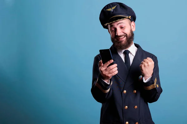 Šťastný Vzrušení Letoun Uniformě Drží Smartphone Dělá Vítězný Gesto Zaťaté — Stock fotografie