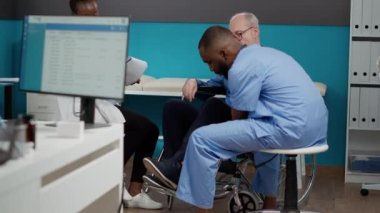Yaşlı bir adamla fizyoterapi seansı yapan tıbbi personel kronik yetersizlik ve sakatlıktan muzdarip. Felç olmuş hasta tekerlekli sandalye kullanıcısı fiziksel konsültasyon, alternatif tıp.
